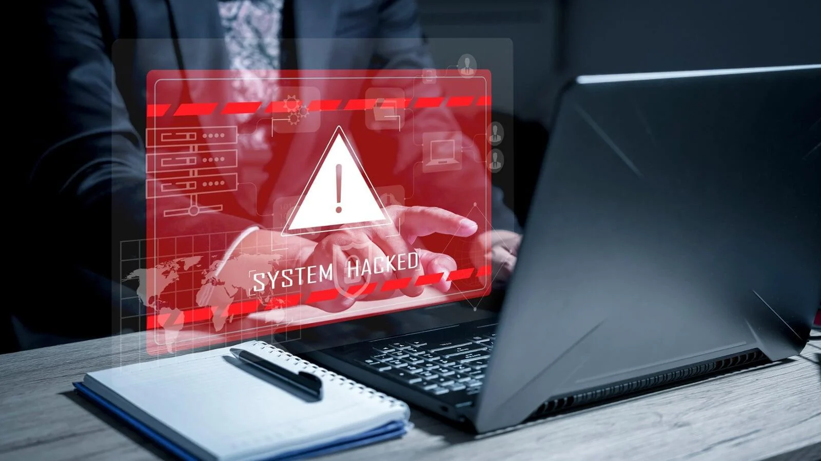Laptop user confronted by a glowing red "SYSTEM HACKED" warning screen, emphasizing the need for managed cybersecurity solutions.