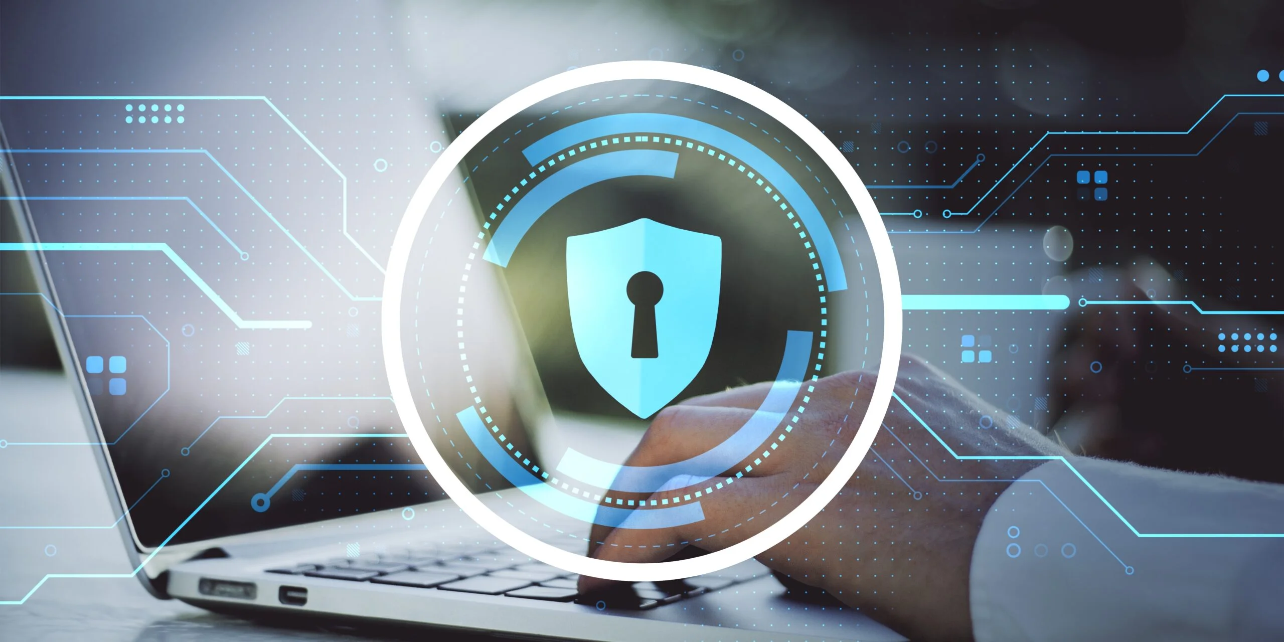 Hands typing on a laptop with an overlaid glowing blue digital shield icon, representing cybersecurity compliance services and data protection.