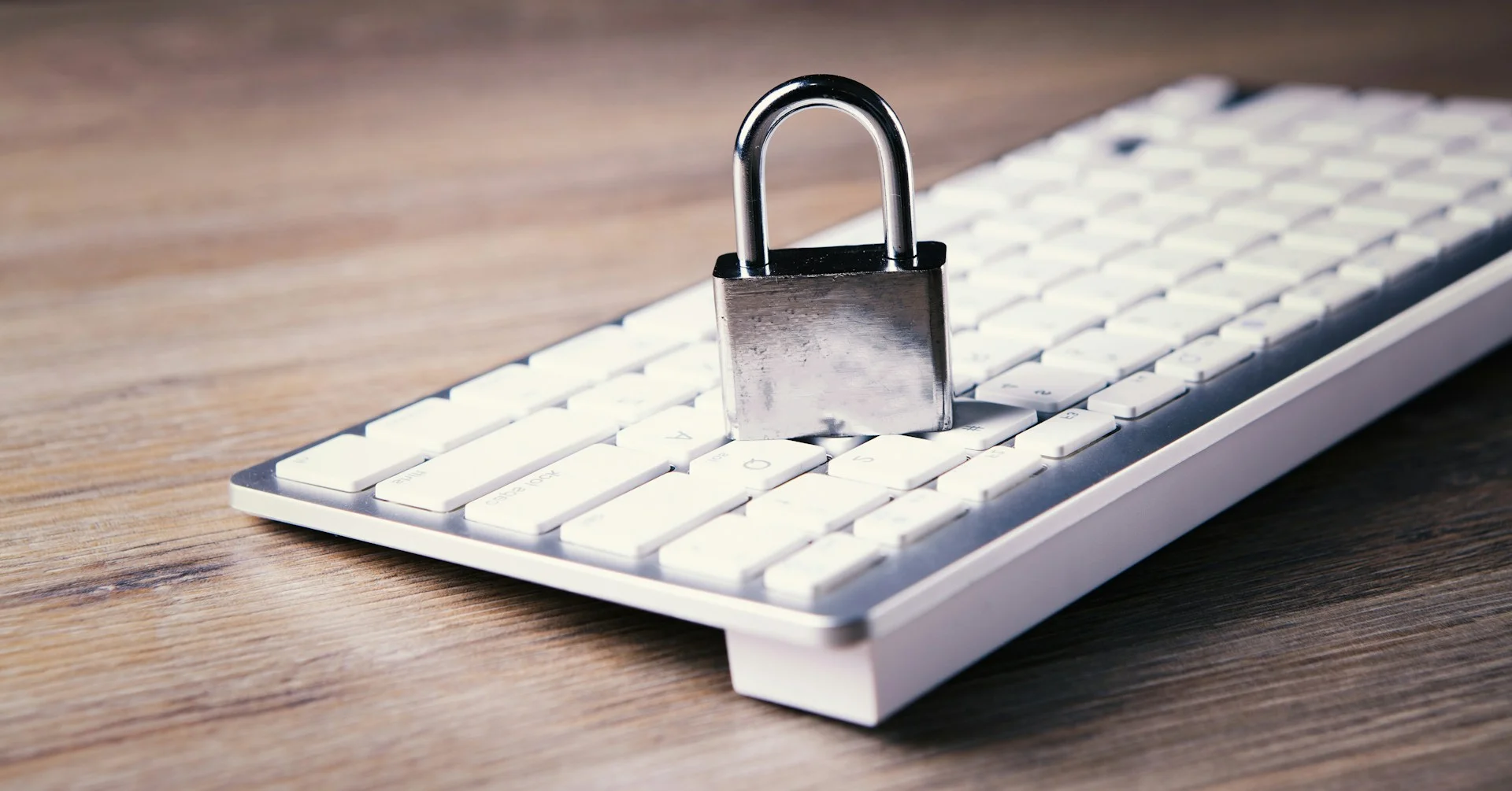 Man using a magnifying glass to view a glowing lock icon, symbolizing the detailed security audit required for the 2025 Privacy Compliance Checklist.