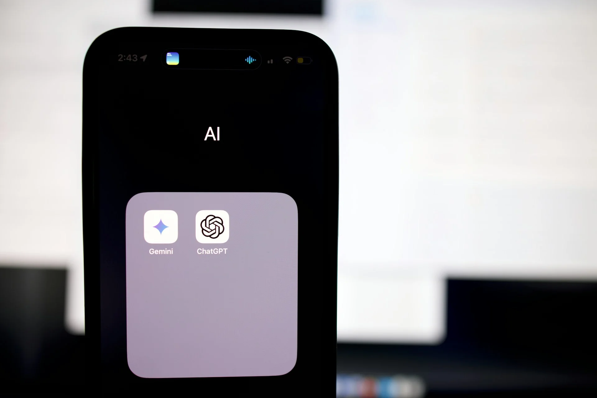 Smartphone screen showing Gemini and ChatGPT icons, symbolizing the need for an AI Governance Policy for Businesses to manage application risk.