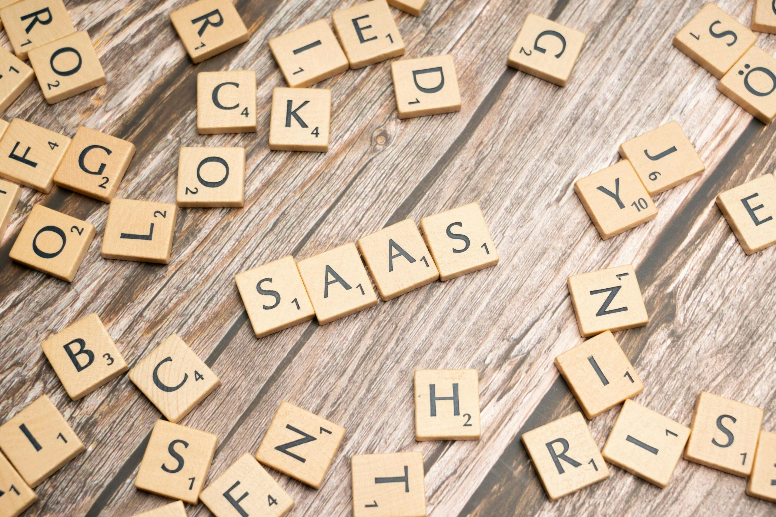 Wooden letter tiles spelling out "SAAS" on a wooden background, representing the initial discovery phase of How to Vet SaaS Integrations.