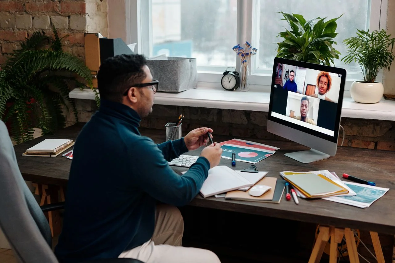 A remote office worker attending a video call on a desktop computer, representing workplace communications susceptible to Small Business Ransomware Attacks.